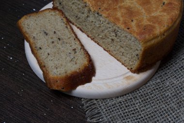 Taze pişmiş ekmek. Bir somun ekmek kesilir ve kesme tahtasının üzerinde yatar..