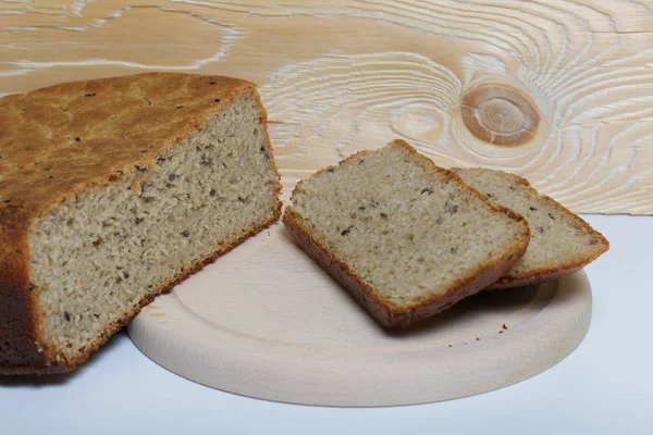 Nybakat bröd. Skivor bröd skärs och ligger bredvid dem på en skärbräda. — Stockfoto