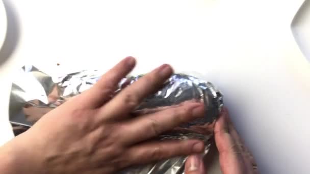 Un homme enveloppe un rouleau de poulet dans du papier d'aluminium. Vue d'en haut . — Video