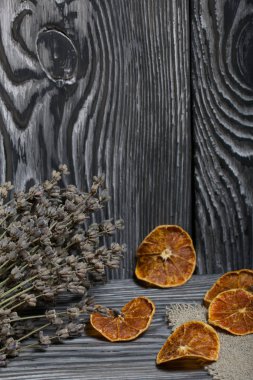 Arkaplanda fırçalanmış bir demet lavanta. Kurutulmuş mandalina dilimleri..