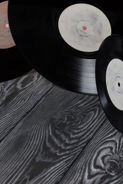 Viejos discos de vinilo. Sobre el fondo de tablas de pino cepillado pintadas en blanco y negro . — Foto de Stock