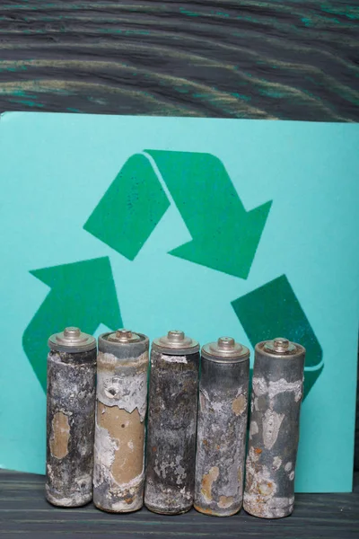 Baterias do dedo da corrosão. Fiquem em fila. No contexto de um sinal de reciclagem de resíduos . — Fotografia de Stock