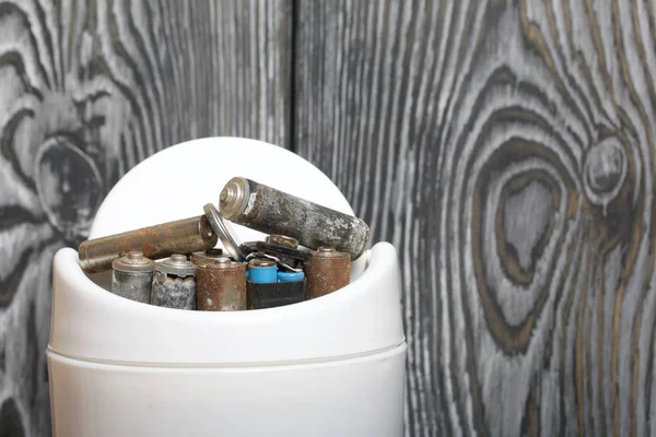 Waste bin. It contains finger-type batteries coated with corrosion. Against the background of brushed pine boards painted in black and white. — 스톡 사진