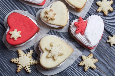 Kartanesi şeklinde kurabiyelerle süslenmiş marshmallow sandviçleri. Siyah beyaza boyanmış çam ağacından tahtalara.