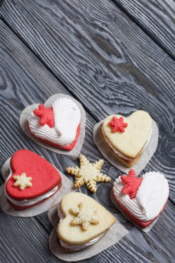 Kartanesi şeklinde kurabiyelerle süslenmiş marshmallow sandviçleri. Siyah beyaza boyanmış çam ağacından tahtalara.