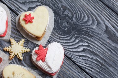 Kartanesi şeklinde kurabiyelerle süslenmiş marshmallow sandviçleri. Siyah beyaza boyanmış çam ağacından tahtalara.