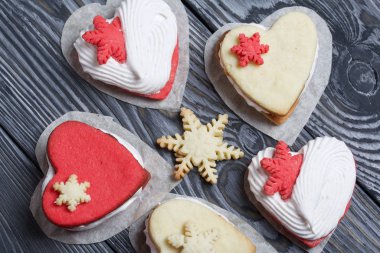 Kartanesi şeklinde kurabiyelerle süslenmiş marshmallow sandviçleri. Siyah beyaza boyanmış çam ağacından tahtalara.