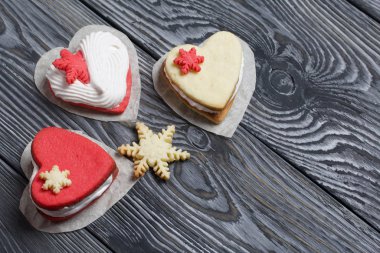 Kartanesi şeklinde kurabiyelerle süslenmiş marshmallow sandviçleri. Siyah beyaza boyanmış çam ağacından tahtalara.