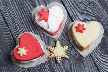 Kartanesi şeklinde kurabiyelerle süslenmiş marshmallow sandviçleri. Siyah beyaza boyanmış çam ağacından tahtalara.