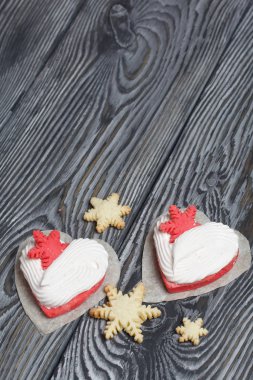 Kartanesi şeklinde kurabiyelerle süslenmiş marshmallow sandviçleri. Siyah beyaza boyanmış çam ağacından tahtalara.