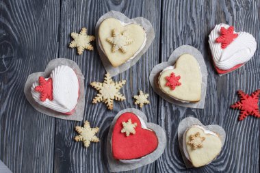 Kartanesi şeklinde kurabiyelerle süslenmiş marshmallow sandviçleri. Siyah beyaza boyanmış çam ağacından tahtalara.