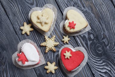 Kartanesi şeklinde kurabiyelerle süslenmiş marshmallow sandviçleri. Siyah beyaza boyanmış çam ağacından tahtalara.