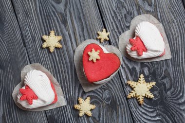 Kartanesi şeklinde kurabiyelerle süslenmiş marshmallow sandviçleri. Siyah beyaza boyanmış çam ağacından tahtalara.