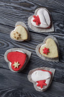 Kartanesi şeklinde kurabiyelerle süslenmiş marshmallow sandviçleri. Siyah ve beyaza boyanmış çam ağaçlarında. Yukarıdan görüntüle.