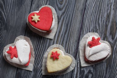 Kartanesi şeklinde kurabiyelerle süslenmiş marshmallow sandviçleri. Siyah ve beyaza boyanmış çam ağaçlarında. Yukarıdan görüntüle.