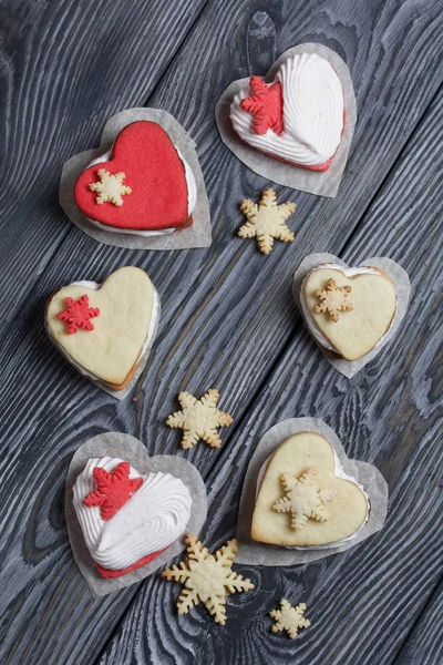 Kartanesi şeklinde kurabiyelerle süslenmiş marshmallow sandviçleri. Siyah beyaza boyanmış çam ağacından tahtalara.