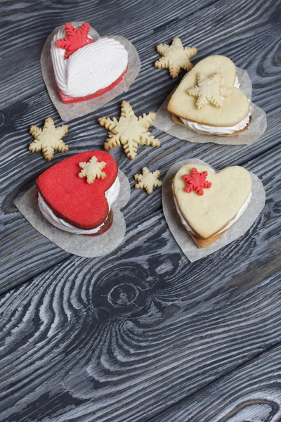 Kartanesi şeklinde kurabiyelerle süslenmiş marshmallow sandviçleri. Siyah beyaza boyanmış çam ağacından tahtalara.