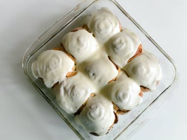 Tabakta çörekler. Biri ikiye bölünmüş, pişmiş çörek katmanları görülebiliyor. Tarçın yıldızlarını süslemek için.