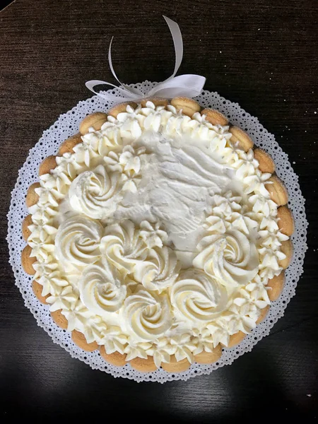 Pastel de esponja con queso crema, decorado con galletas Savoiardi. En el costado, envuelto en una cinta atada a un lazo . — Foto de Stock