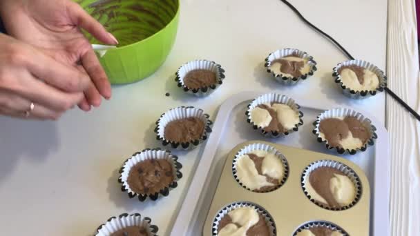Egy nő csokoládét ad a tésztához a süteményes edényekben. Márványtortát készítek. Közelkép. — Stock videók