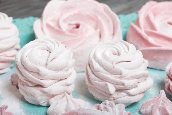Zarte rosa Marshmallows in verschiedenen Formen. Liegt auf einem türkisfarbenen Tablett. Mit Puderzucker bestreut. — Stockfoto