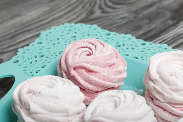 Marshmallows rosa delicado de várias formas. Deita-se numa bandeja azul-turquesa. Polvilhado com açúcar de confeiteiro . — Fotografia de Stock