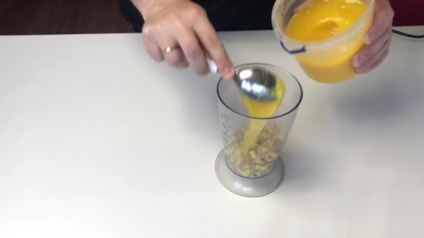 一个男人在搅拌机碗里加了一勺蜂蜜.碗里有切碎的生姜片.用蜂蜜烹调生姜. — 图库视频影像