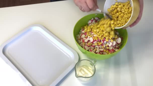 Ein Mann macht einen Salat aus Pekinger Kohl. Mixt gehackten Kohl, gehackte Krabbenstangen, Mais und Mayonnaise. — Stockvideo