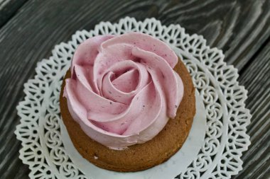 Çikolata hamuru ve yaban mersinli marşmelovdan yapılmış marshmallow sandviçleri. Bir gül şeklinde olsun. Dantel bir peçeteye, fırçalanmış çam ağacından tahtalara. Yakın çekim..