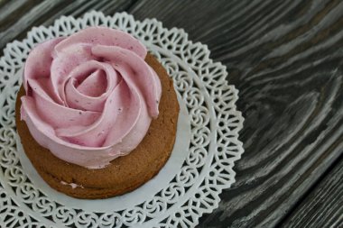 Çikolata hamuru ve yaban mersinli marşmelovdan yapılmış marshmallow sandviçleri. Bir gül şeklinde olsun. Dantel bir peçeteye, fırçalanmış çam ağacından tahtalara. Yakın çekim..