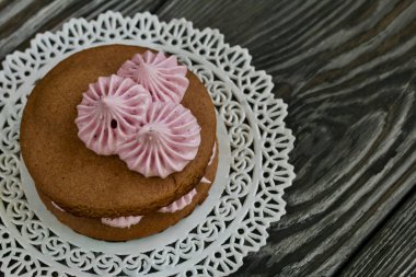 Çikolata hamuru ve yaban mersinli marşmelovdan yapılmış marshmallow sandviçleri. Kupa şeklinde kurabiyelerle süslenmiş. Çam ağacından yapılmış tahtalarda. Yakın çekim..