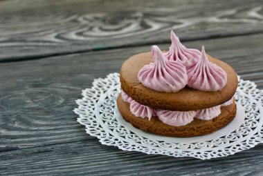 Çikolata hamuru ve yaban mersinli marşmelovdan yapılmış marshmallow sandviçleri. Dantel bir peçeteye, fırçalanmış çam ağacından tahtalara. Yakın çekim..