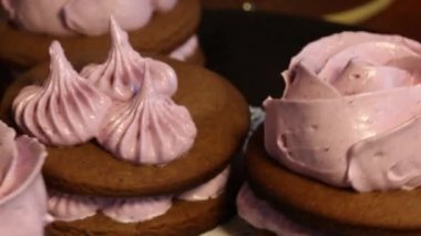 Çikolata hamuru ve yaban mersinli marşmelovdan yapılmış marshmallow sandviçleri. Bir gül şeklinde olsun. Dönen vinil plağa monte edilmiş. Yakın çekim.