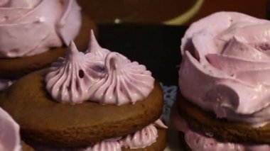 Çikolata hamuru ve yaban mersinli marşmelovdan yapılmış marshmallow sandviçleri. Bir gül şeklinde olsun. Dönen vinil plağa monte edilmiş. Yakın çekim..