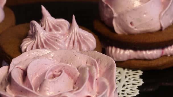 Panini ai marshmallow a base di pasta al cioccolato e marshmallow ai mirtilli. Sotto forma di rosa. Su un disco di vinile rotante. Primo piano. — Video Stock