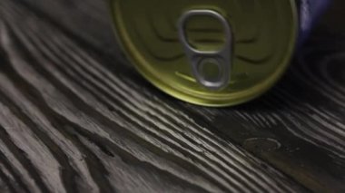 Bir teneke kutu tahtaların üzerinde yan yatar. Açılış için görünür bir halka. Yakın çekim..