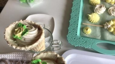 Waffle külahındaki şekerlemeler gözlük takıyor. Tepsinin yanında çeşitli şekil, renk ve boyutlarda yeni hazırlanmış bir lokum var. Yukarıdan ateş edildi.