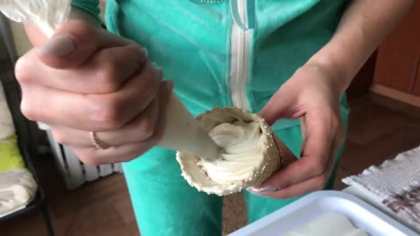 Cucinare i marshmallow. Una donna che usa una borsa da pasticceria e un ugello riempie il cono del waffle con un marshmallow. Lo mette su un vassoio — Video Stock