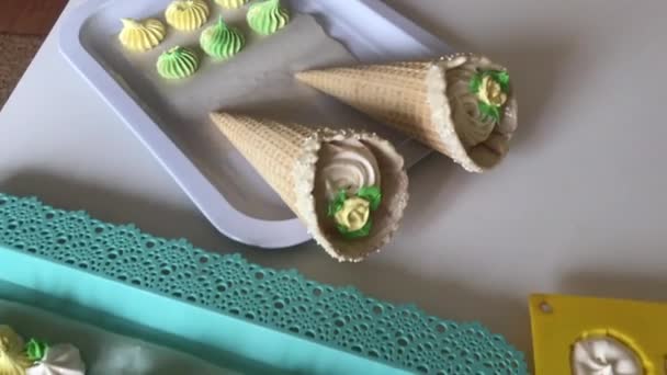 다양 한 모양, 색깔, 크기의 마시멜로를 요리합니다. 완성 된 제품은 쟁반 위에 놓여 있다. 와플 콘에 들어 있는 마시멜로는 안경을 쓰고 서 있다. — 비디오