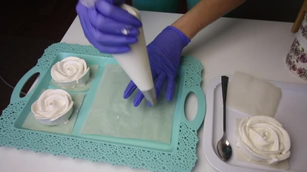 盘子里放着一朵玫瑰花形式的棉花糖.一个女人用糕点袋和喷嘴从棉花糖中拿出一个经典的棉花糖. — 图库视频影像