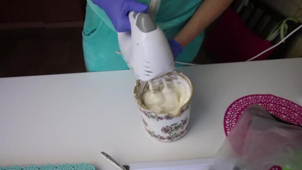 Una donna che usa un frullatore prepara un marshmallow in un contenitore . — Video Stock