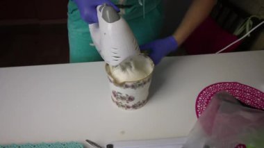 Blender kullanan bir kadın marshmallow ve agar şurubunu bir kabın içinde karıştırıyor..