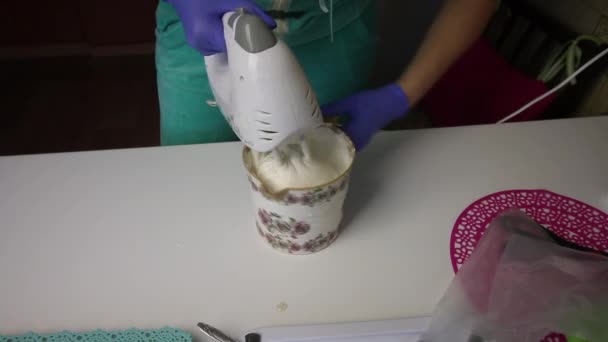 Woman using a blender mixes marshmallow and agar agar syrup in a container. — Stock Video