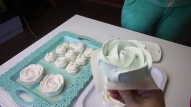 Marshmallow 'lar tezgahta bir gül şeklinde. Bir kadın alır ve tepsiye koyar..