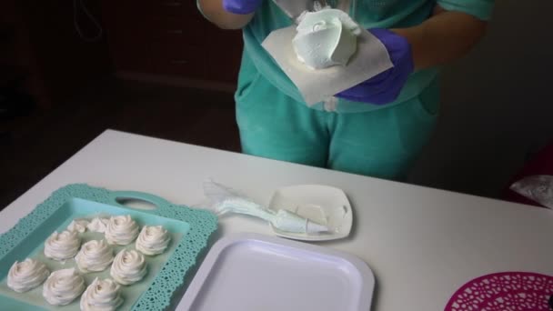 Een vrouw die een banketzak en een mondstuk gebruikt, vormt een marshmallow in de vorm van een roos. Maakt de bloemblaadjes. Vlakbij op een dienblad is een marshmallow voor stabilisatie. — Stockvideo