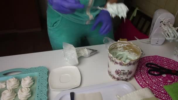 Una mujer pone malvavisco en una bolsa de pastelería. Cerca en una bandeja es un malvavisco para la estabilización . — Vídeo de stock