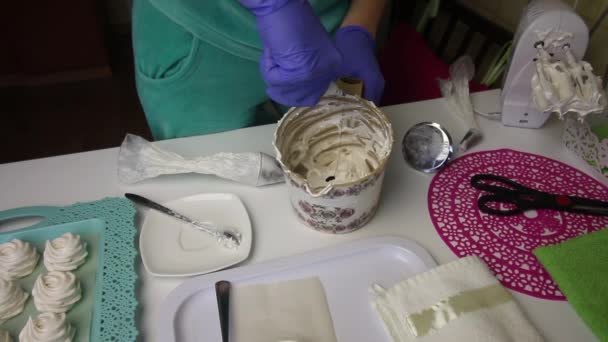 En kvinna tillsätter en droppe grönt färgämne till marshmallow. Blandningar med en mixer. — Stockvideo