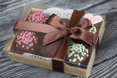 Çikolatayla kaplanmış patatesli pasta. Cevizle süslenmiş, çikolata damlaları ya da serpiştirilmiş. Fırçalanmış tahtaların arka planına karşı.