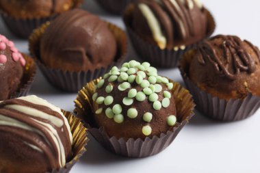 Çikolatalı patatesli kek. Bazısı şekerle, bazısı çikolatayla süslenmiş. Beyaz arkaplanda.