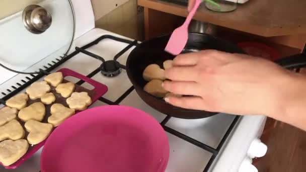 Vrouw friet koekjes in een pan. Verwijdert het deksel, draait het koekje om. Klaar voor een bord. Tijdsverloop. — Stockvideo